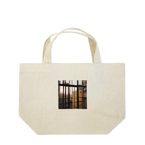 窓から覗く荒廃した建物が立ち並ぶ無人の通り Lunch Tote Bag